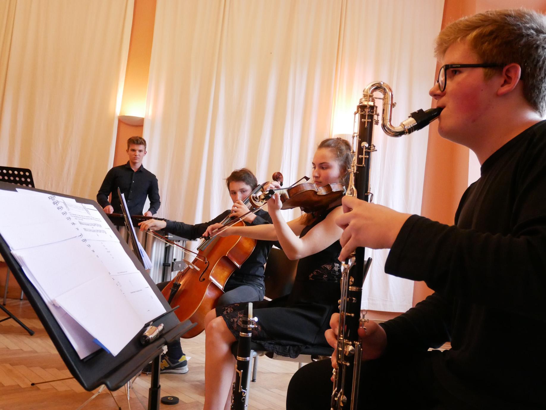 Junge Musikerinnen an Klarinette, Geige, Cello und Schlagwerk
