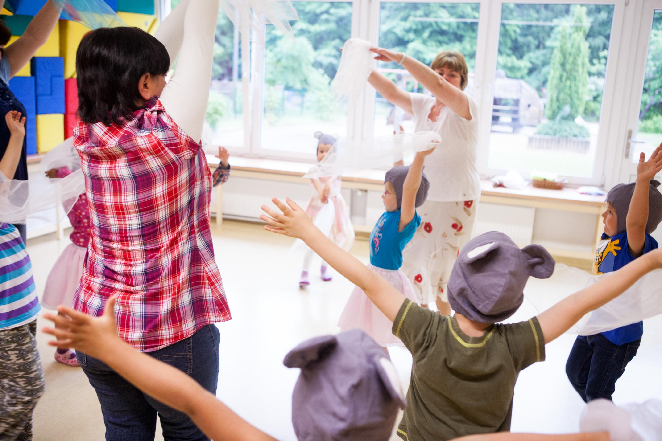 Eine Gruppe Erwachsene und Kinder tanzen mit Tüchern