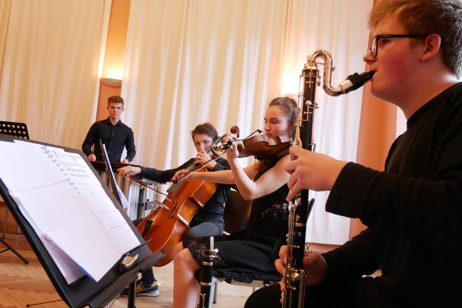 Junge Musikerinnen an Klarinette, Geige, Cello und Schlagwerk