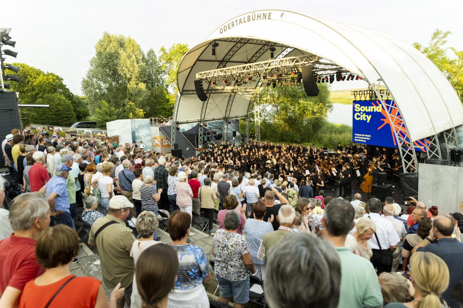 Ansicht auf die Odertalbühne mit Publikum und der Jungen Philharmonie Brandenburg beim Sound City Festival 2023 in Schwedt/Oder