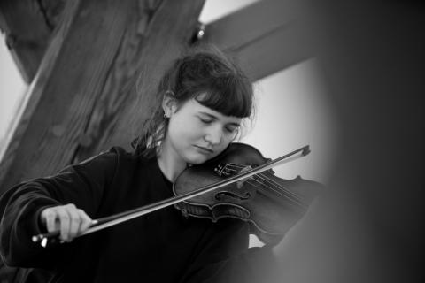 Foto Schwarz/weiß, junge Frau spielt mit geschlossenen Augen Geige