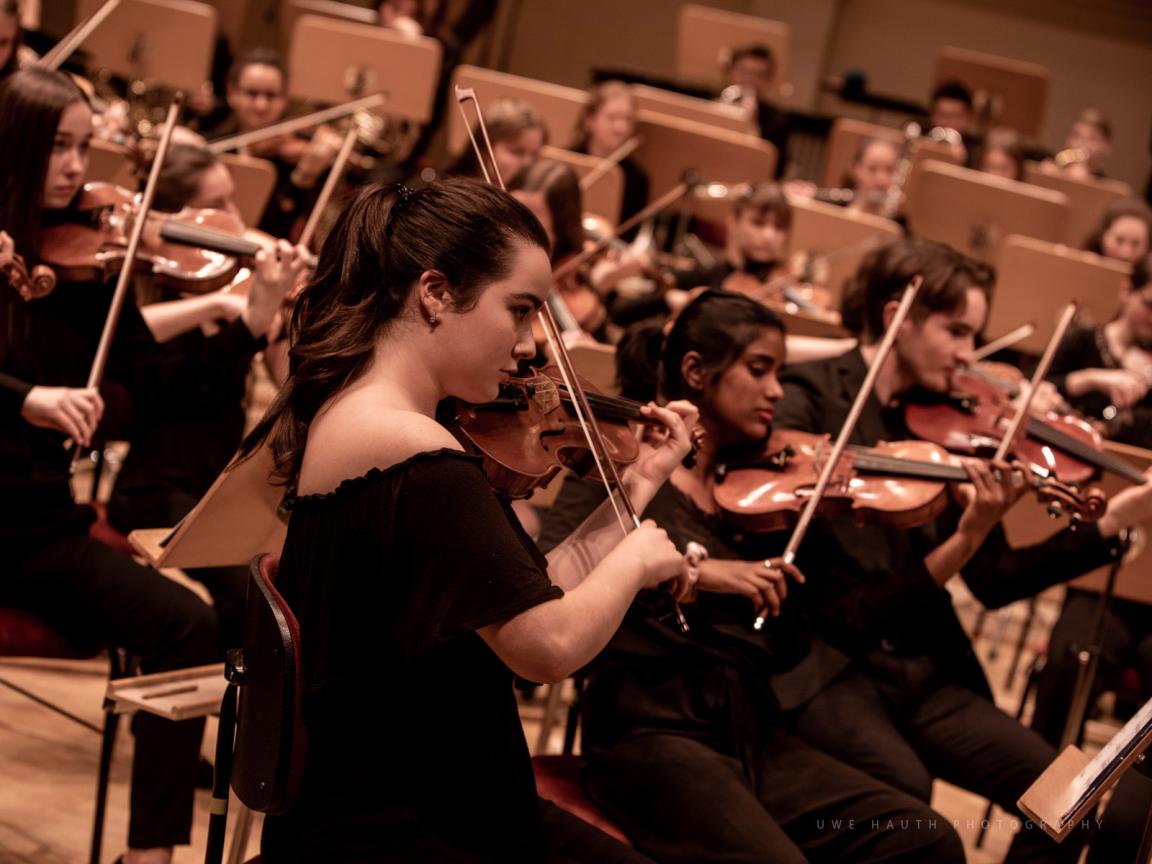 Junge Musikerinnen und Musiker mit Violinen