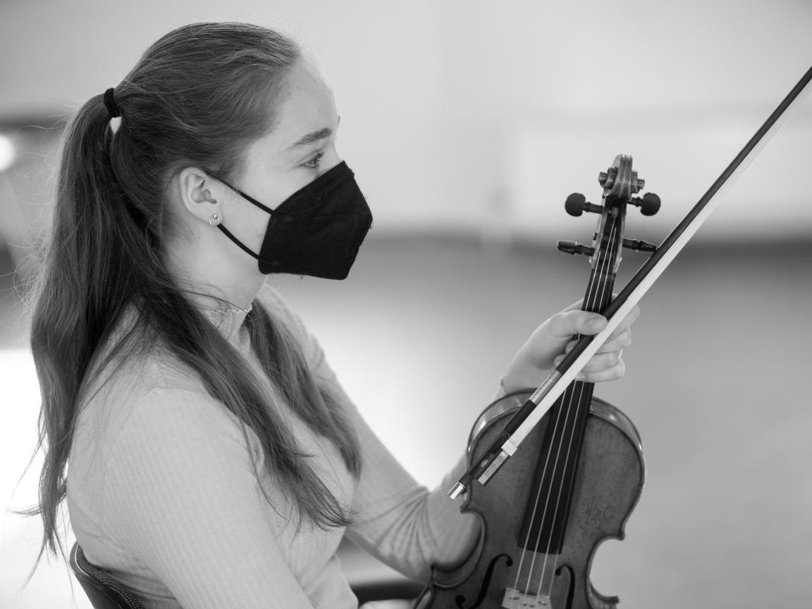 Junge Frau mit Maske und Geige