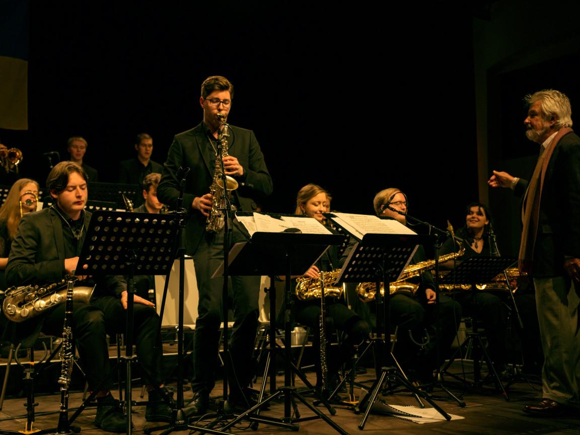Konzert des LaJJazzO in Potsdam, ein junger Saxofonist spielt ein Solo während der künstlerische Leiter Jiggs Whigham dirigiert